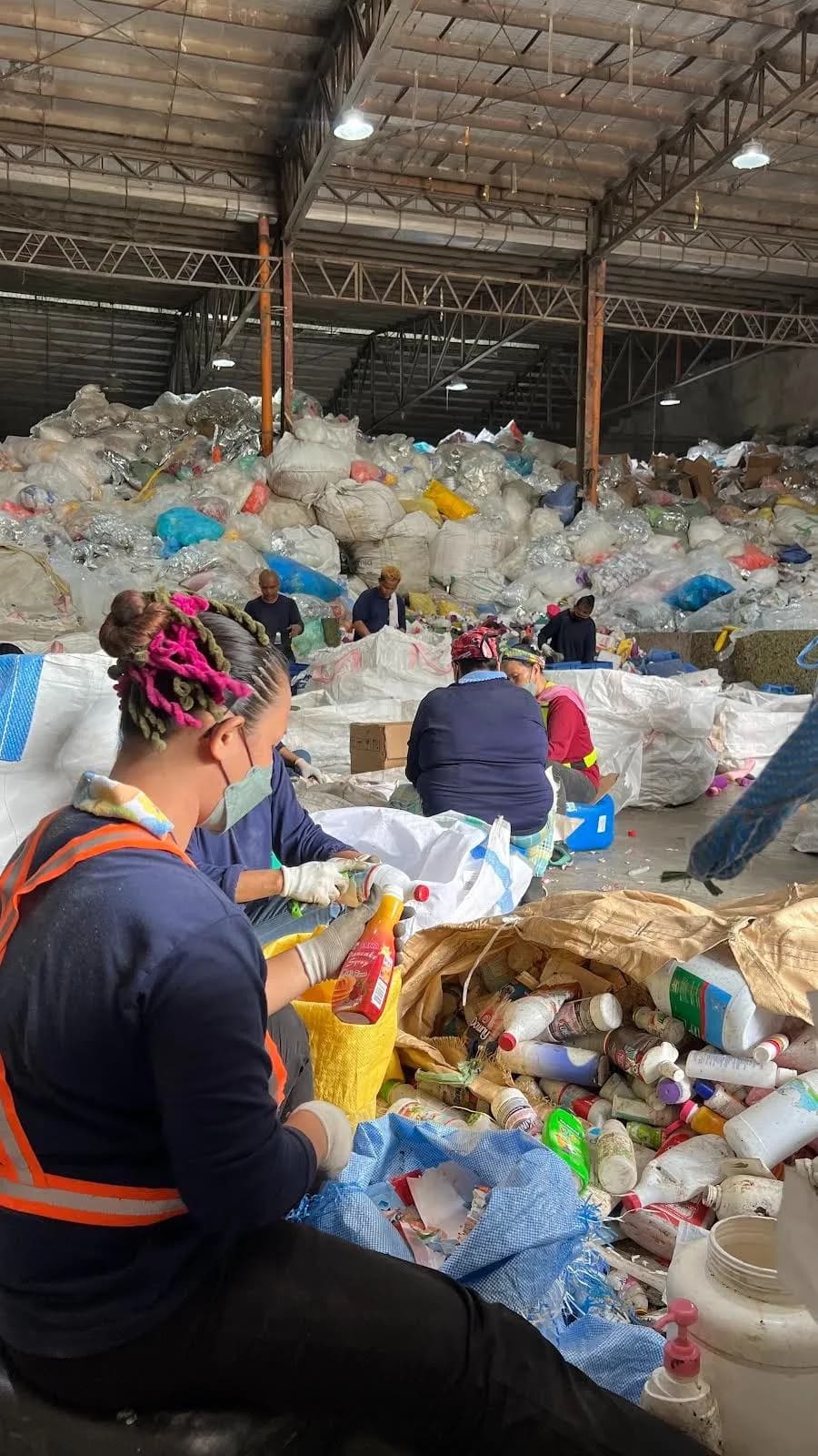 Workers sorting plastic waste at The Plastic Flamingo recycling facility