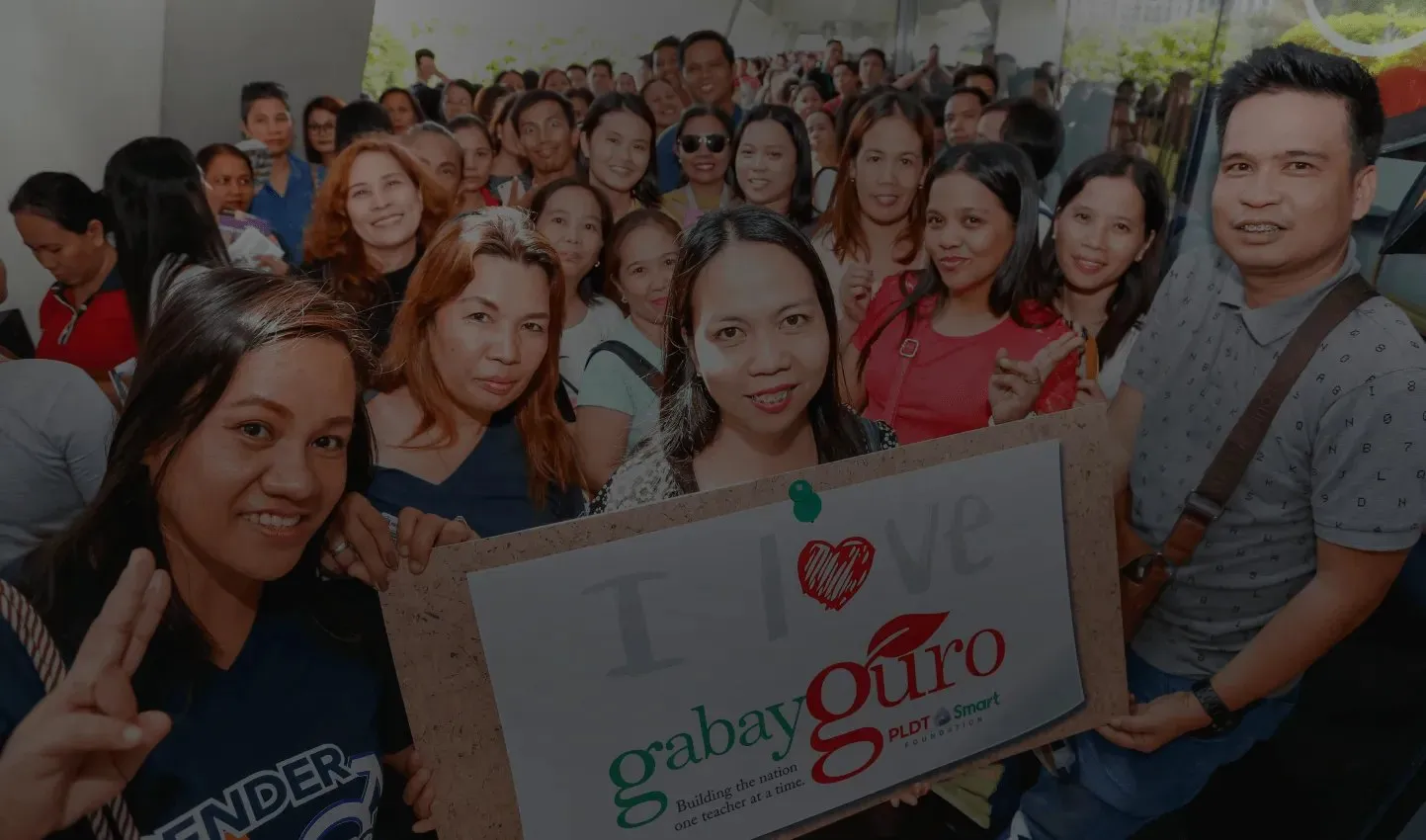 Smiling public school teachers holding an "I love Gabay Guro" sign at a PLDT-Smart Foundation event