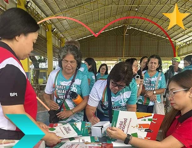 Women in matching shirts filling out materials at a community financial education session