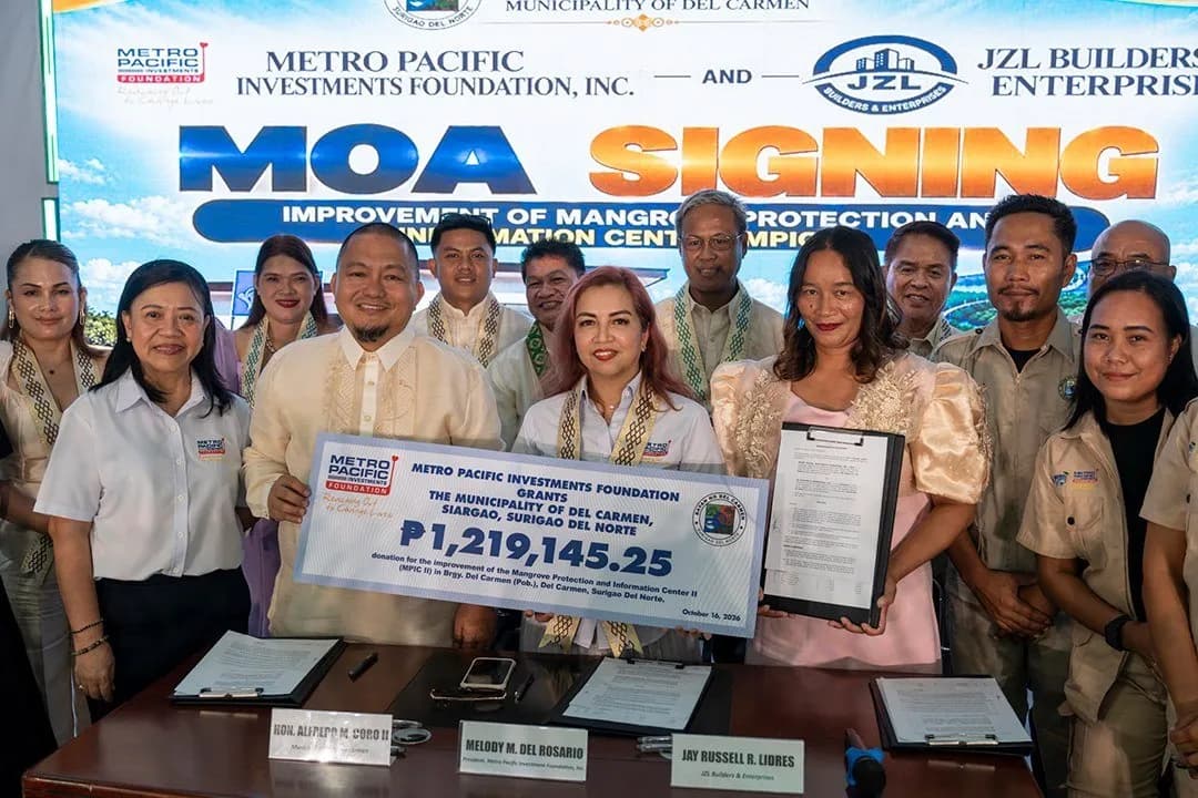 Officials and staff holding a ceremonial check for ₱1,219,145.25 at a MOA signing in Del Carmen, Siargao